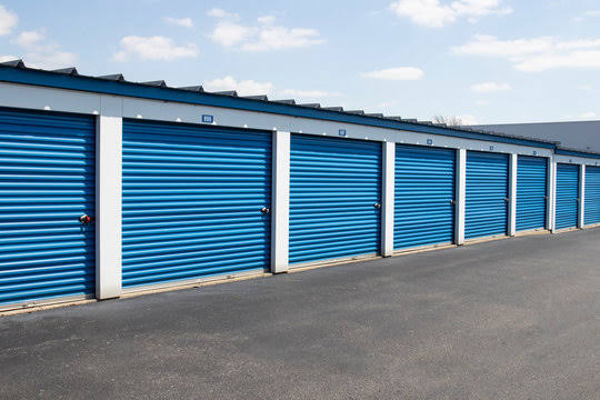 Rows of secure, blue roll-up door self-storage units at Safe Storage Solutions